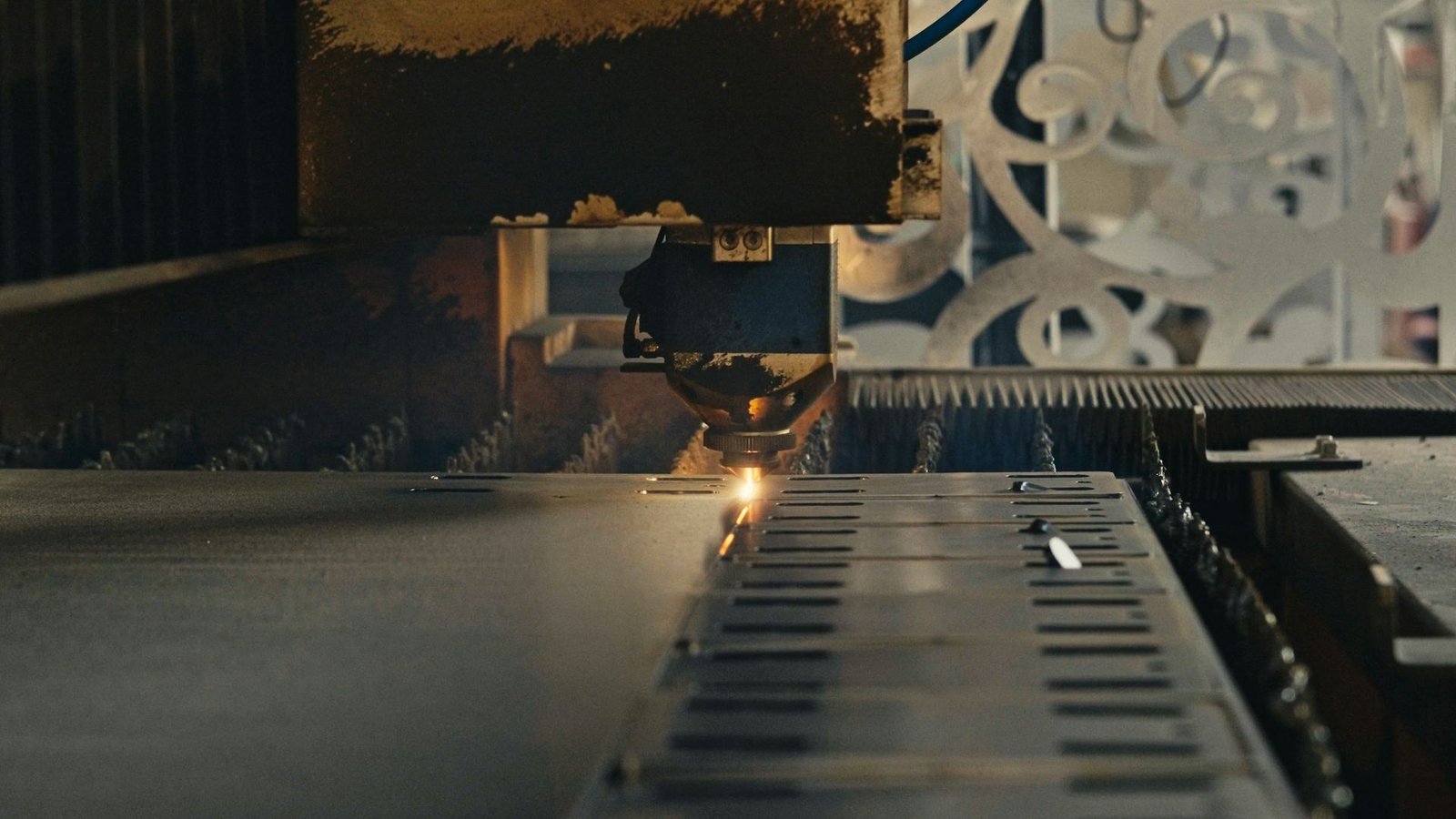 Cabeçote de laser CNC cortando detalhes precisos em chapa metálica na RDR Laser Metal